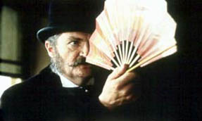 Gilbert warily regards a Japanese fan, as the inspiration for The Mikado dawns on him.